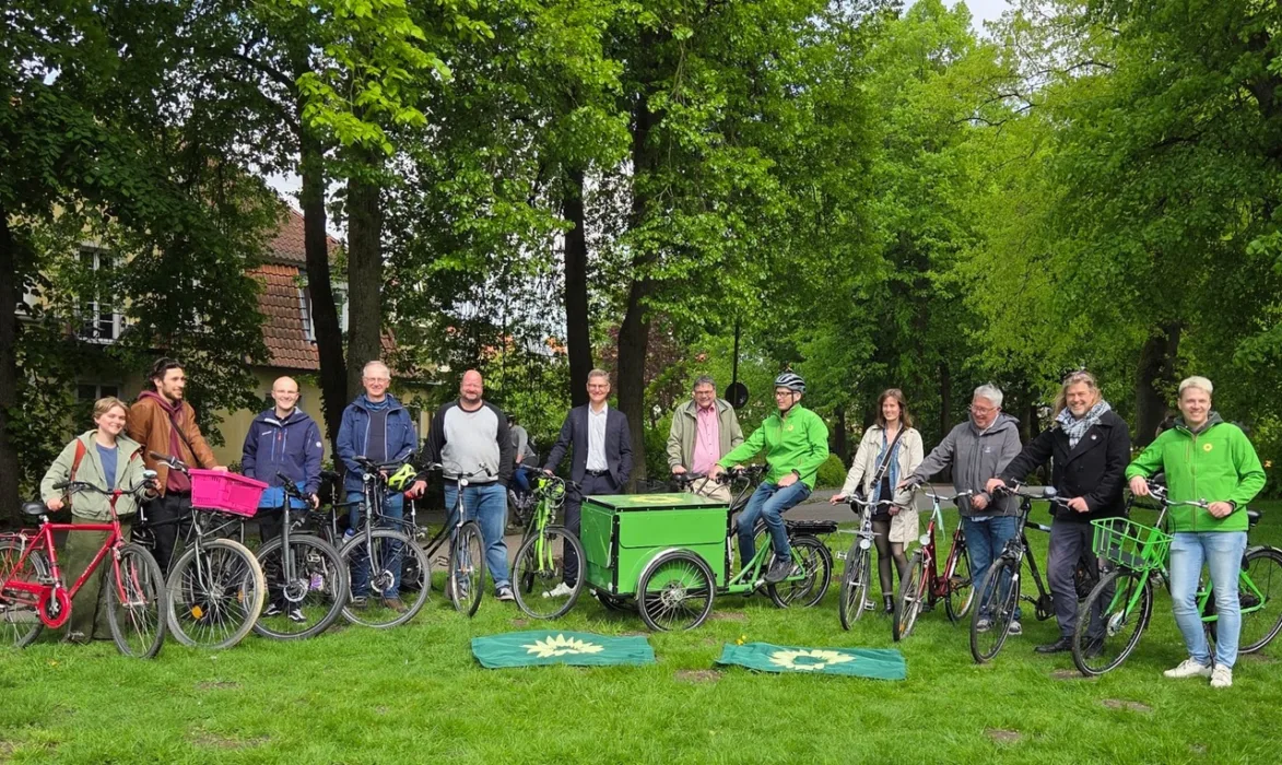 Menschen stehen mit ihren Fahrrädern in einer Reihe für ein Gruppenfoto
