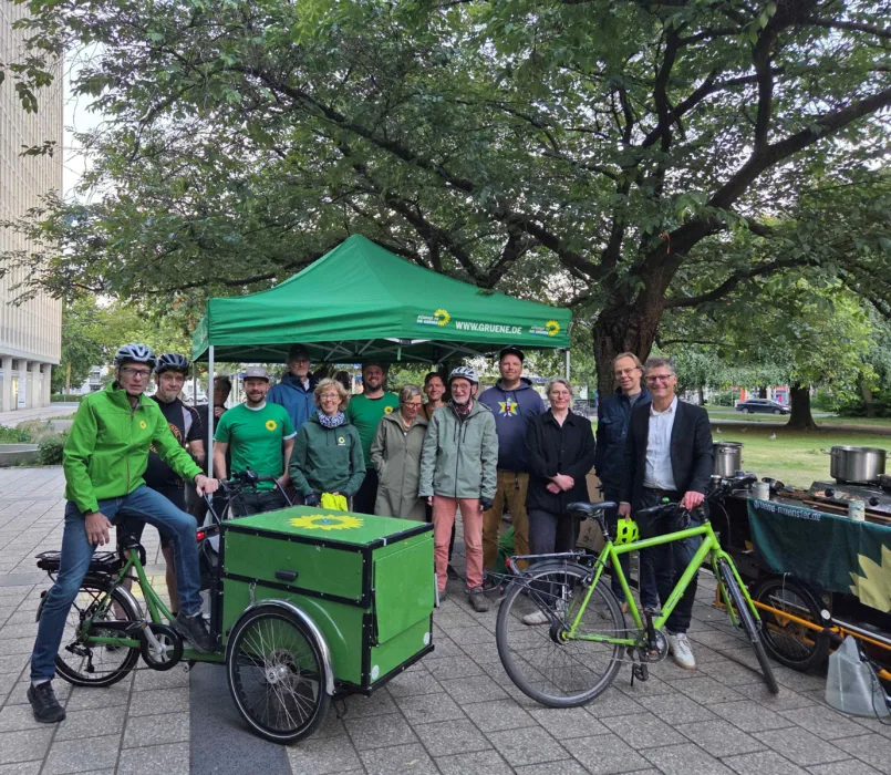 Eine Gruppe Grüner steht mit ihren Fahrrädern für ein Gruppenfoto zusammen