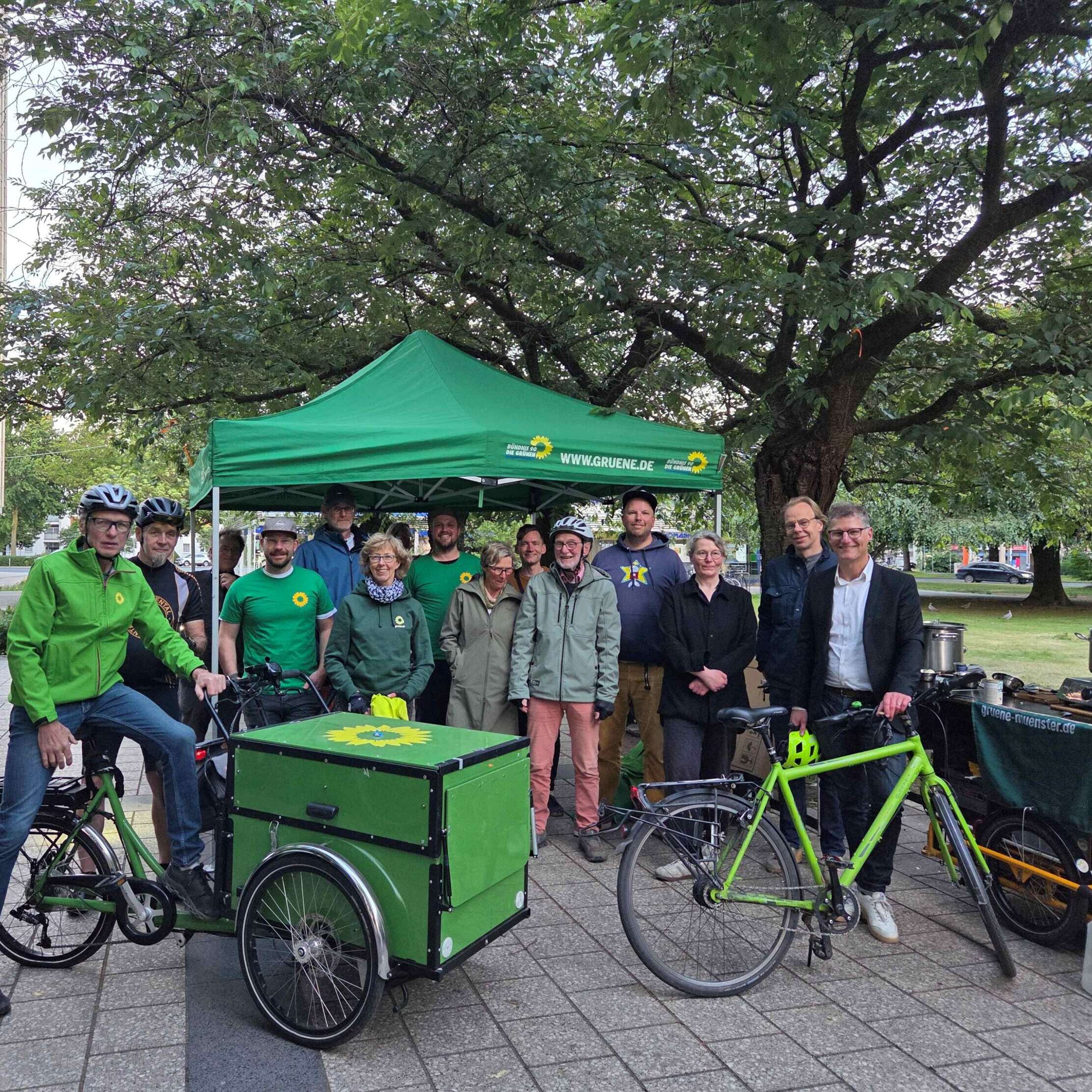 Eine Gruppe Grüner steht mit ihren Fahrrädern für ein Gruppenfoto zusammen
