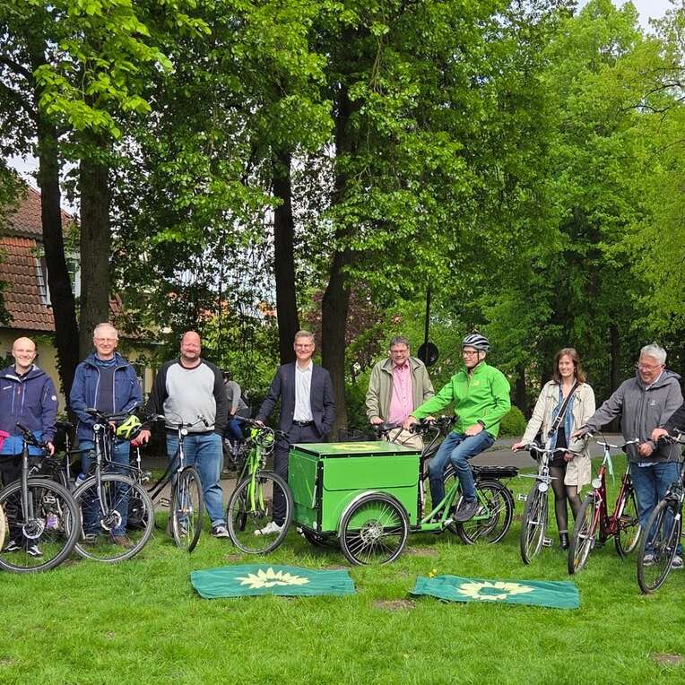 Menschen stehen mit ihren Fahrrädern in einer Reihe für ein Gruppenfoto