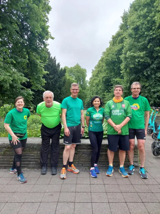 Mehrere Läufer*innen stehen in Grünen T-Shirts nebeneinander