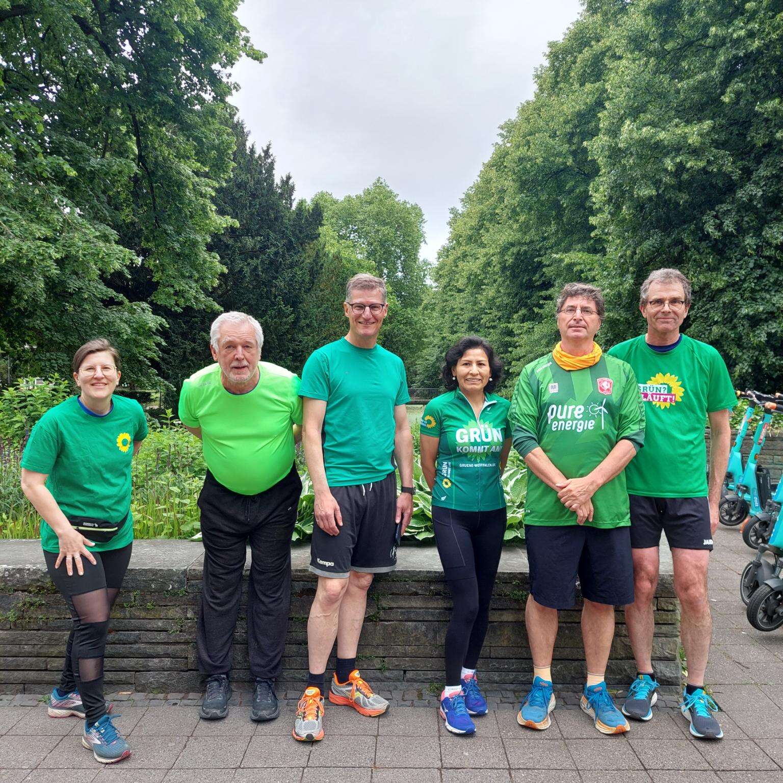 Mehrere Läufer*innen stehen in Grünen T-Shirts nebeneinander