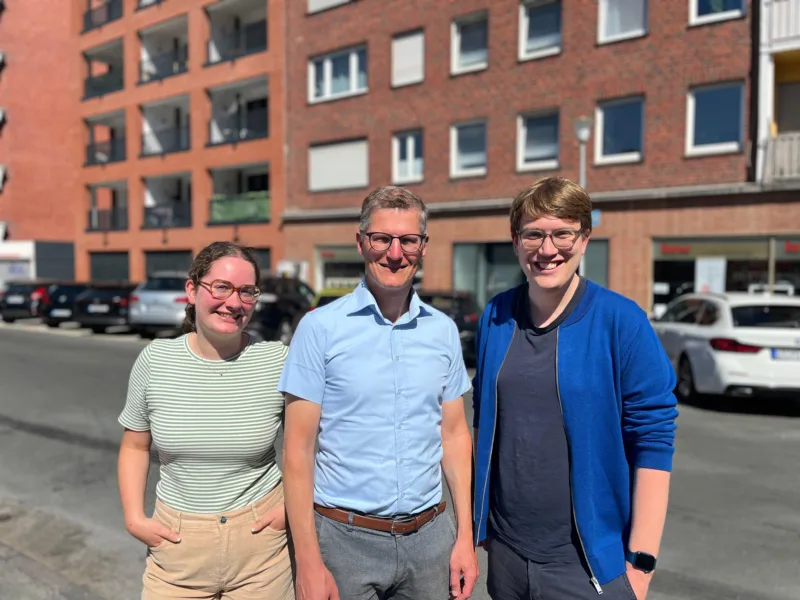 Marie Diekmann, Tilman Fuchs und Albert Wenzel vor einem Wohngebäude