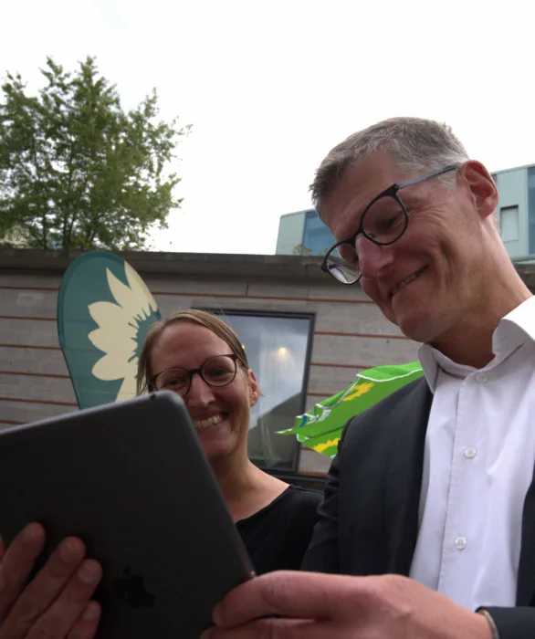 Birgit Wolters und Tilman Fuchs schauen sich den Chatbot auf einem Tablet an