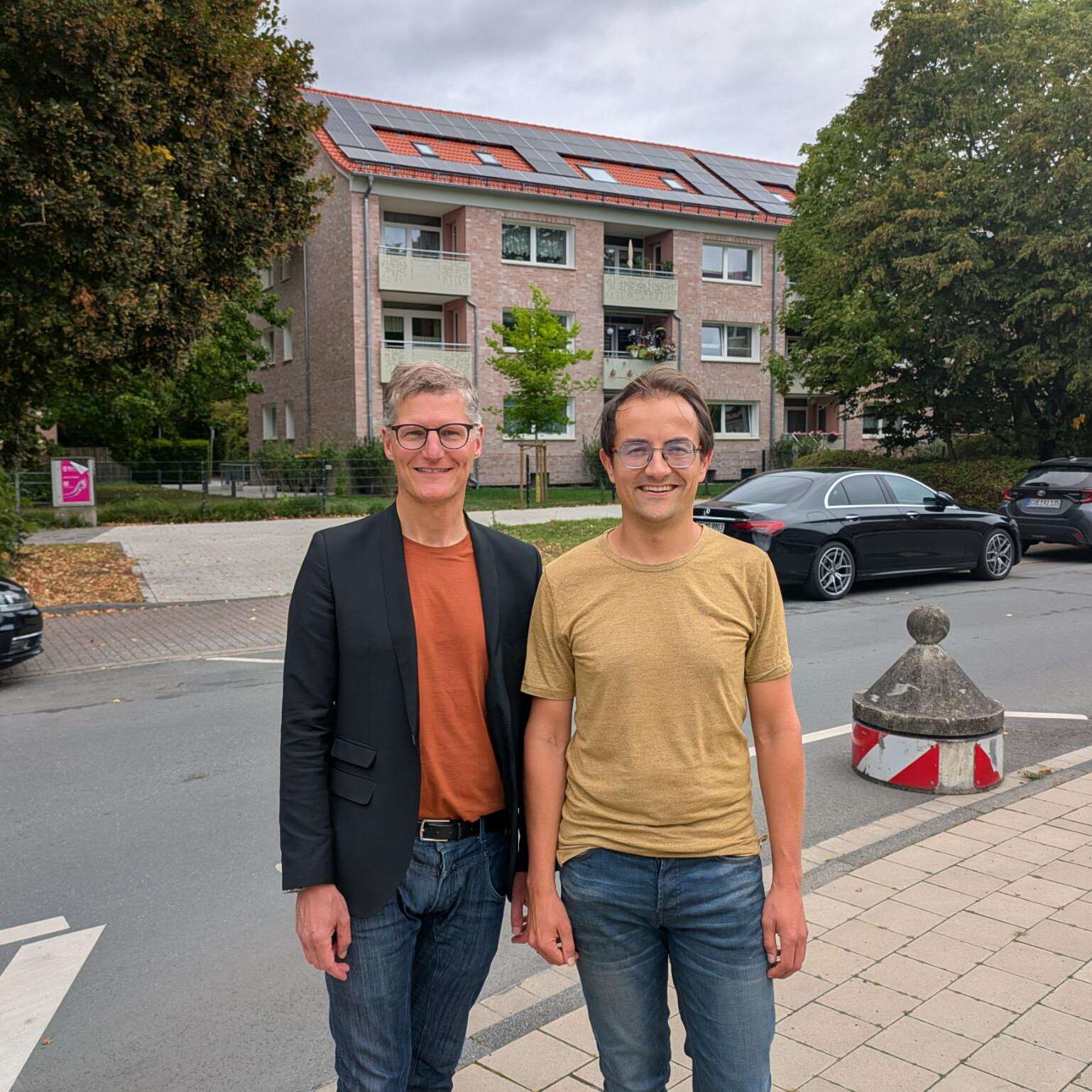 Tilman Fuchs und Robin Korte vor den neuen Photovoltaik-Anlagen auf den Dächern von Wohn+Stadtbau Gebäuden in der Aaseestadt