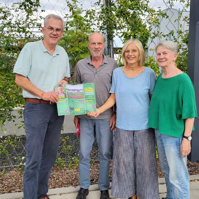 Bezirksbürgermeister Benedikt Spangenberg und die BV-Kandidat*innen Bodo Kensmann, Heike Deckert-Peaceman und Margret Wesseling mit einem Grünen Flyer