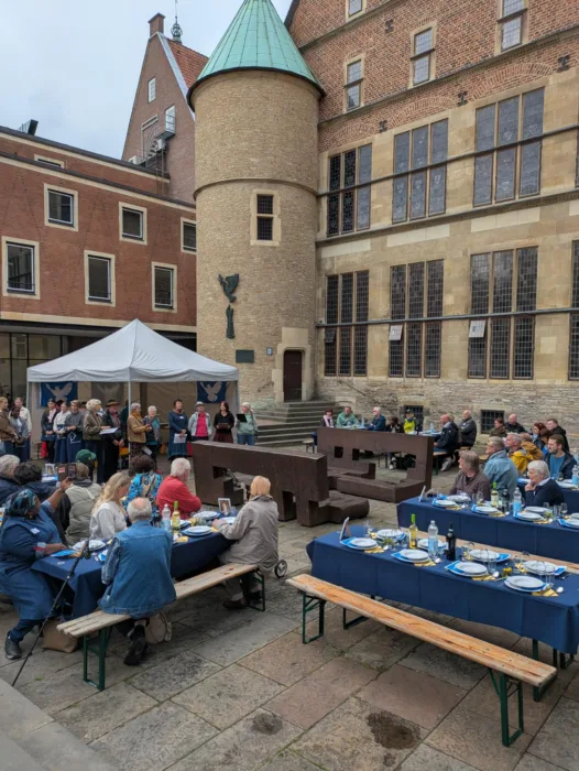 Menschen sitzen zusammen beim Friedensmahl